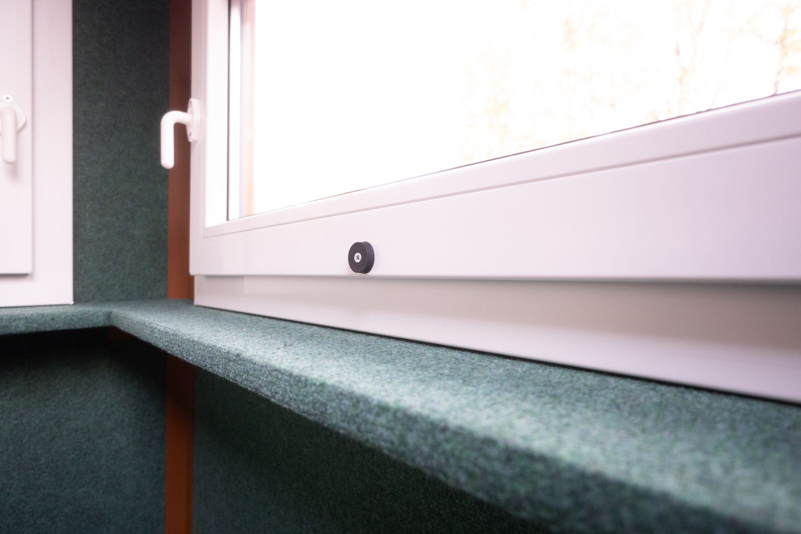 Auflagebrett mit grünem Filz unter dem Fenster