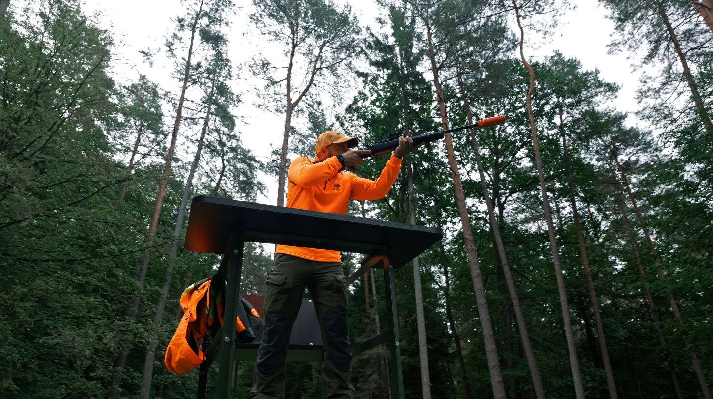 Jäger im Anschlag auf dem Zauberjagd Drückjagdbock im Kiefernwald